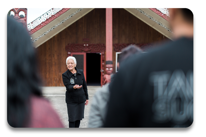 Kaikaranga standing in front of the marae