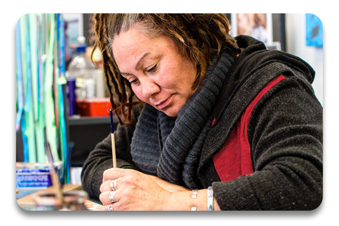 Tauira at a desk writing down ideas for inspiration in the Toi Maruata course