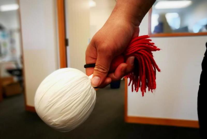 White and red poi in right hand 